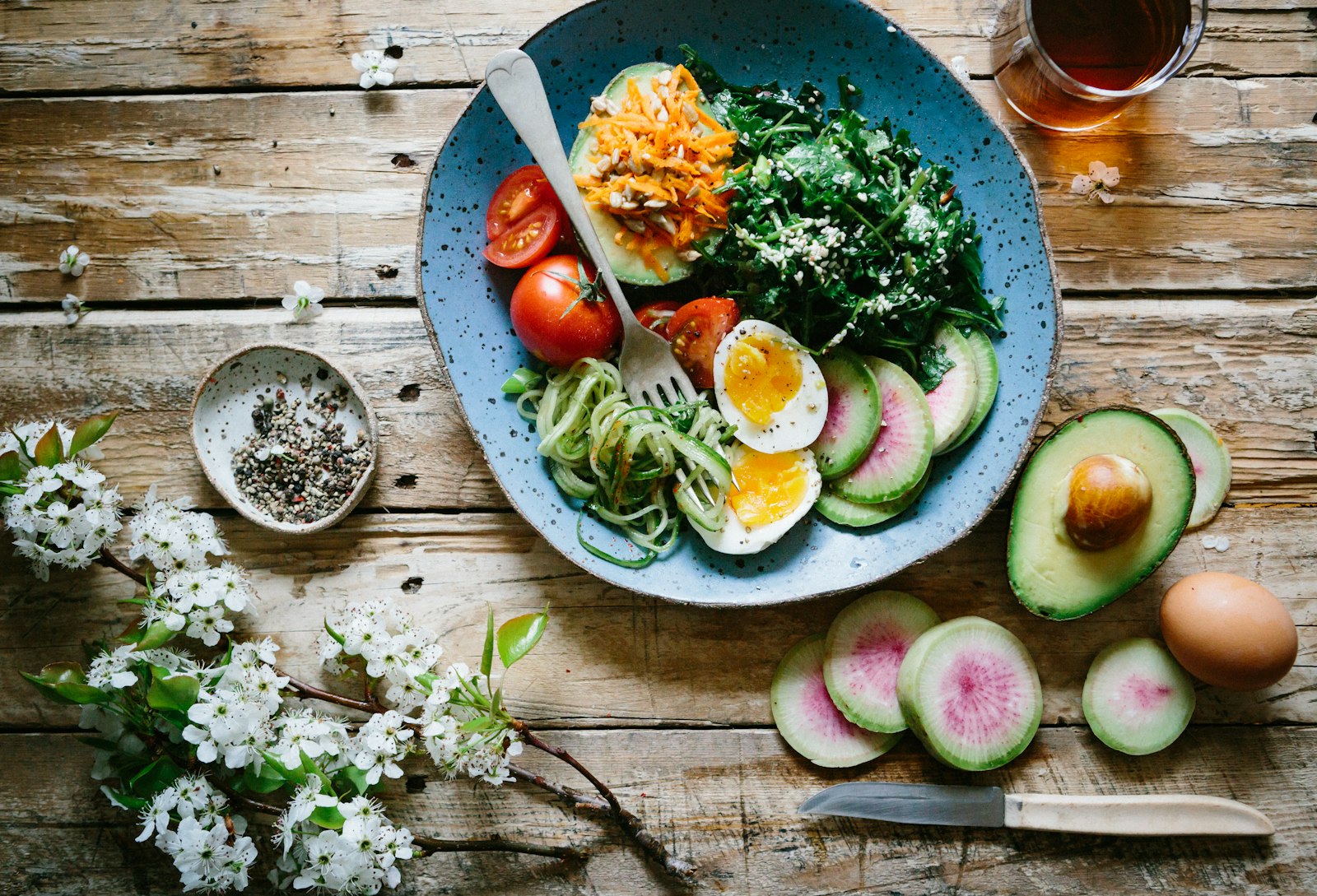 Overhead view of a colorful plate with leafy greens, vegetables, and protein.